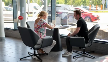 "Klientka rozmawia z doradcą w salonie MG podczas zakupu samochodu